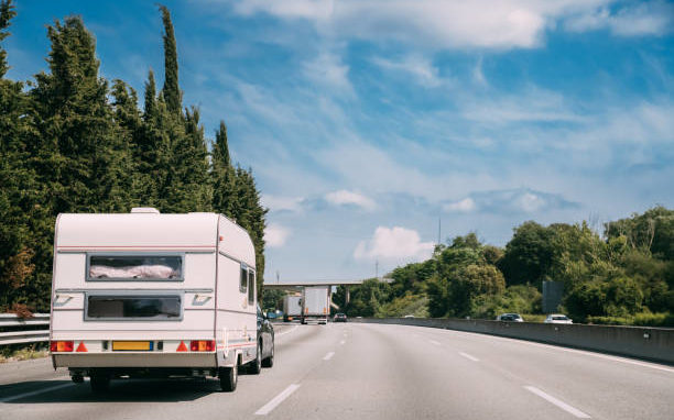 White Caravan Motorhome Car Goes On Highway Road.